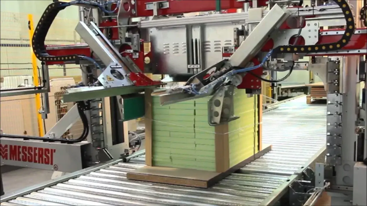 Automatic horizontal strapping machine applying strap to a palletised load