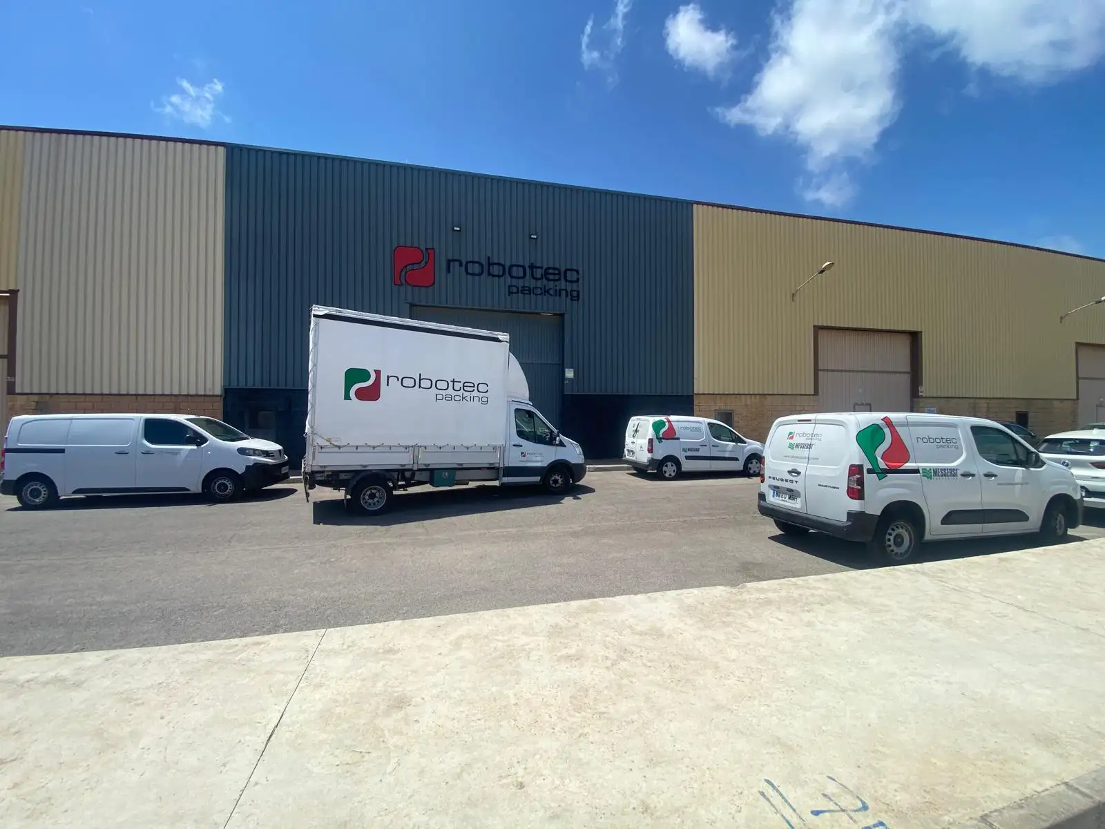 Flota de vehículos del servicio SAT Robotec frente a las instalaciones de Robotec Packing