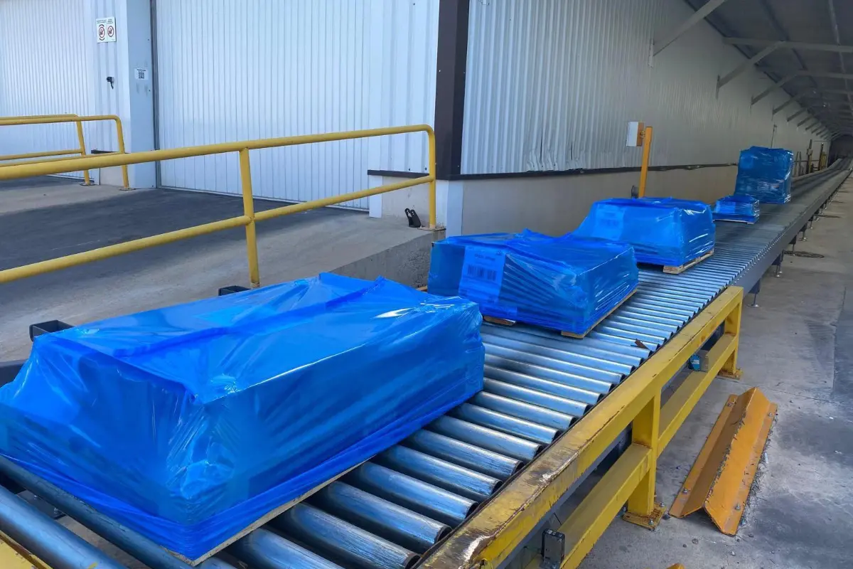 Mit Stretch-Hood-Folie verpackte Paletten auf einer industriellen Förderlinie