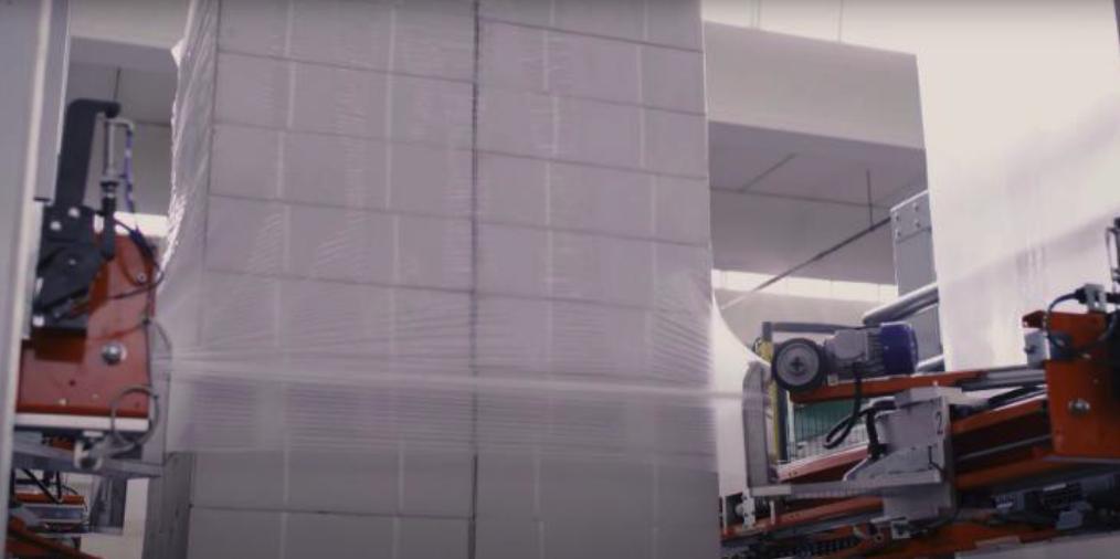 Stretch-Hood-Maschine beim Aufbringen der Stretchhaube auf eine Palette in einer automatischen Linie