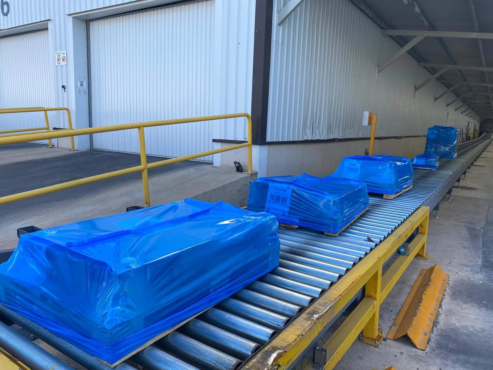 Detalle del enfundado Stretch Hood en una línea de picking cerámico